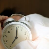 photo of person holding alarm clock