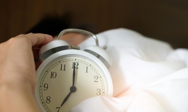 photo of person holding alarm clock